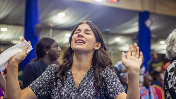 Layna worshipping with hands raised on the mission field
